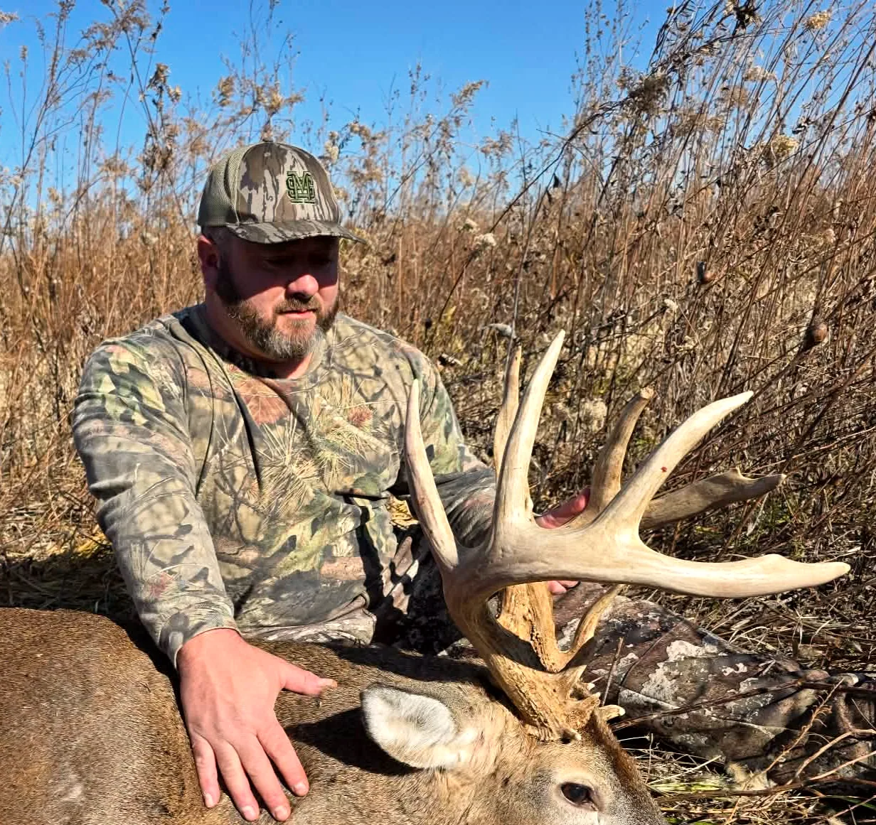 Hunter with a heavy Illinois whitetail rack on managed ground in Henderson County