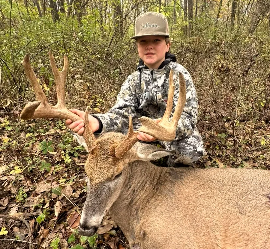 Young hunter with a mature Illinois whitetail buck taken on a Kids Hunt Free adult booking